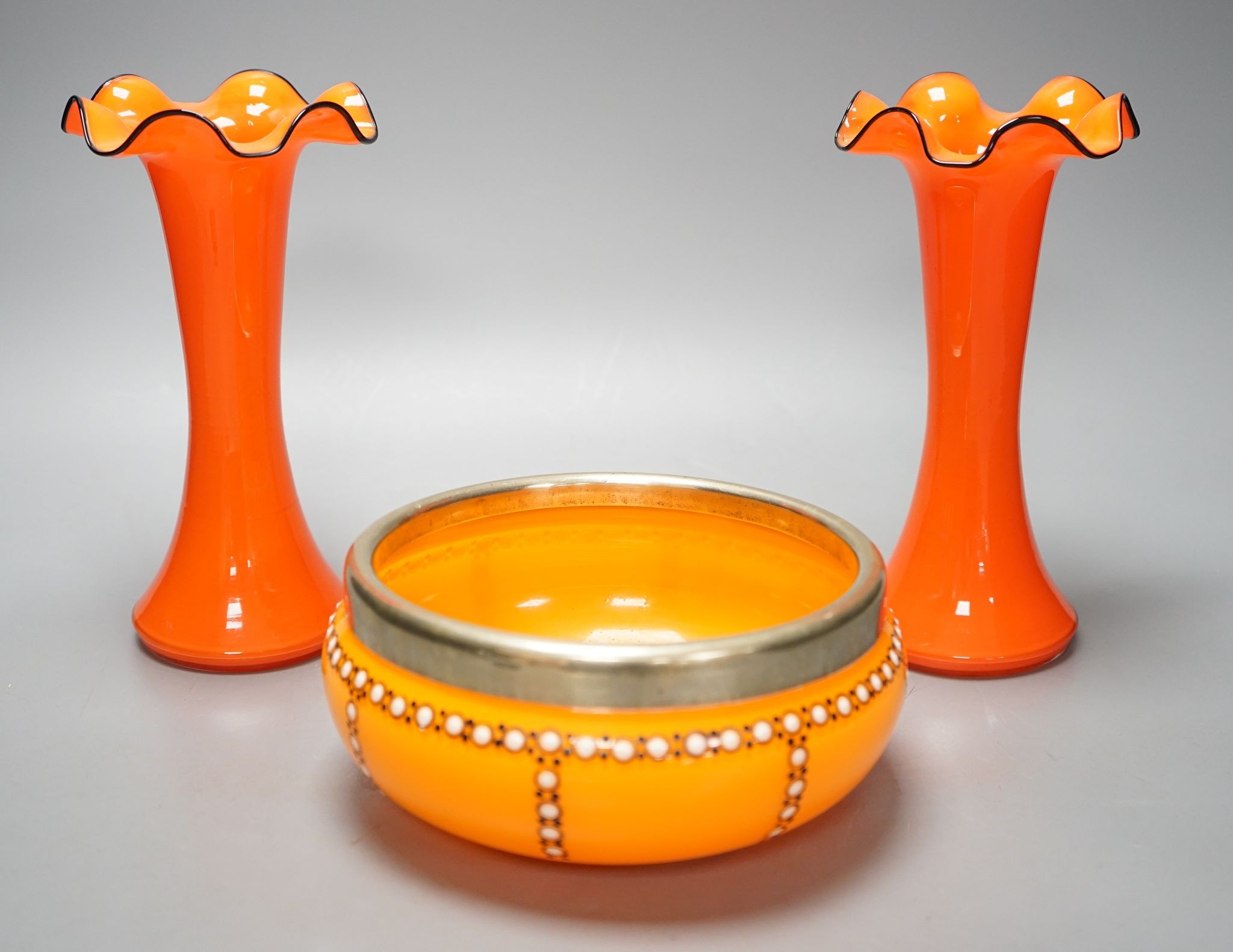 A tangerine glass bowl with silver plated mount to rim and a pair of spill vases, in the style of Michael Powdry, tallest 21cm
